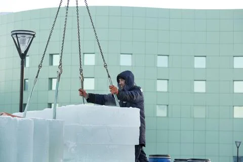 Worker in blue jacket unloading ice panels 스톡 사진