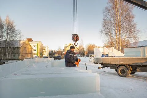 Worker in blue jacket unloading ice panels 스톡 사진