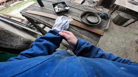 Worker in blue protective overalls and gloves opens a can of brown varnish 스톡 동영상 335234305
