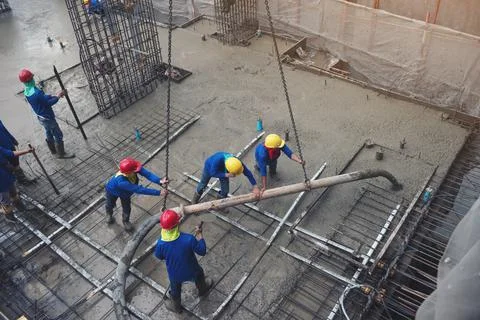 The worker in blue working in construction site with cement Foto stock