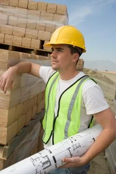 Worker With Blueprint At Construction Site Foto stock