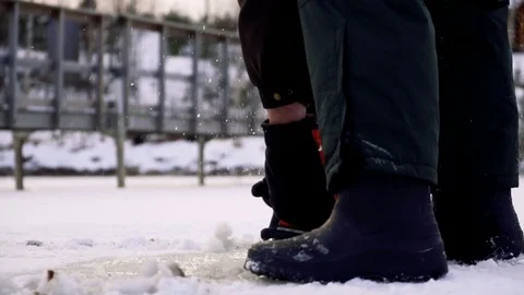 Worker in boots cut ice of frozen lake by chainsaw Vídeos de archivo 72769598