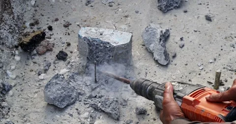 Worker breaking concrete foundation base with demolition hammer at construction 库存影片 348893031
