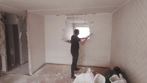 Worker Breaking Interior Wall During Apartment Renovation Project Indoors Stock Footage 338431236