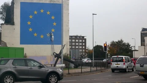 A worker breaks away at one of the golden stars from the eu flag graffity 스톡 동영상 102564542