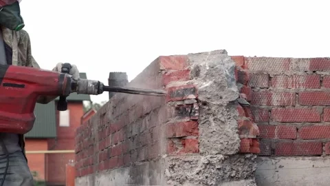 Worker breaks concrete at a construction site. Powerful hammer drill breaks Video stock 133293078