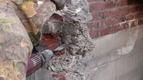 Worker breaks concrete at a construction site. Powerful hammer drill breaks Video stock 133293250