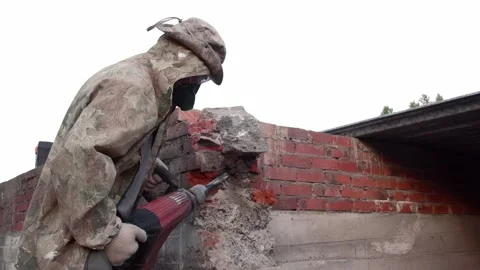 Worker breaks concrete at a construction site. Powerful hammer drill breaks Video stock 133293404