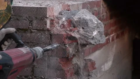 Worker breaks concrete at a construction site. Powerful hammer drill breaks 動画素材 133293601