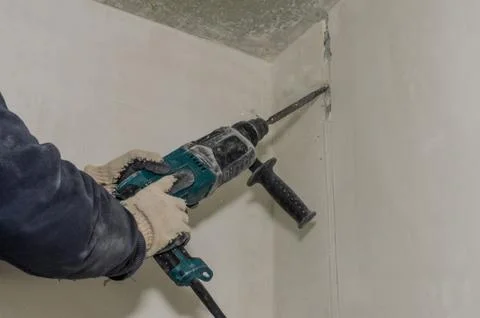 Worker breaks a concrete wall with a perforator chisel Stock Photos