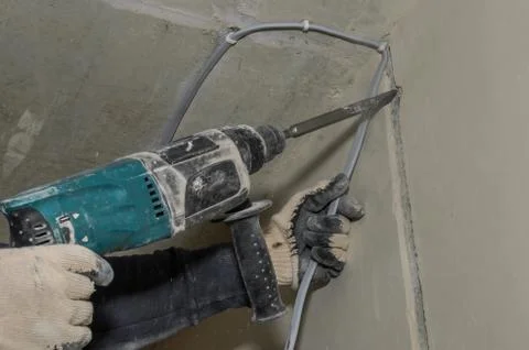 Worker breaks a concrete wall with a perforator chisel Stock Photos