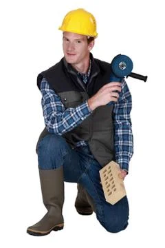 Worker with a brick and grinder Stock Photos