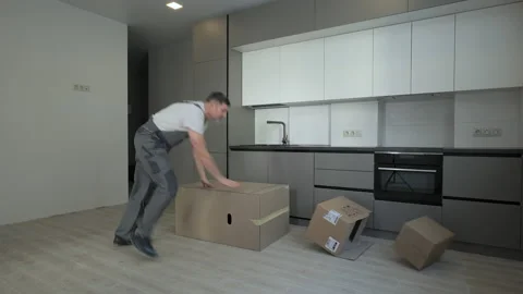 A worker brings boxes to a new apartment and the boxes fall on the floor Stock Footage 171758522