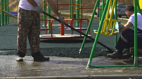 A worker brushes cover concrete, bitumen-rubber primer. Stock Footage 91720685