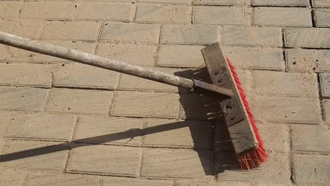 Worker brushing sand in to joints of newly laid block paving on a driveway Stock Footage 112191600
