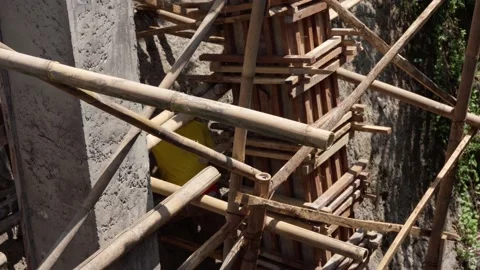 Worker-builder of bamboo scaffolding construction site in asia. He works on Stock Footage 237366788