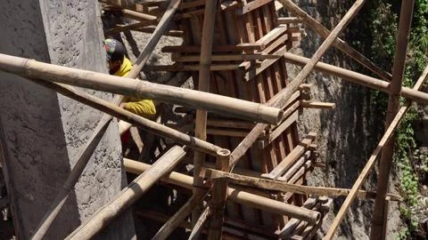 Worker-builder of bamboo scaffolding construction site in asia. He works on Stock Photos