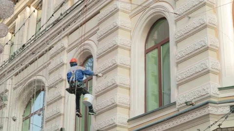 Worker builder high-rise restores a historic building fasade Stock-Footage 164809918