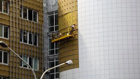 Worker builder making construction for ventilation facade on a building wit.. Stock Photos