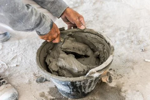 Worker builder mix cement in bucket. Preparation for glue the tiles Stock-Fotos
