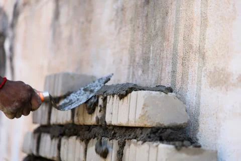 Worker building a brick wall with trowel closeup Stock Photos