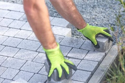 Worker building a new interlocking pavement from concrete paving, a new path Stock Photos