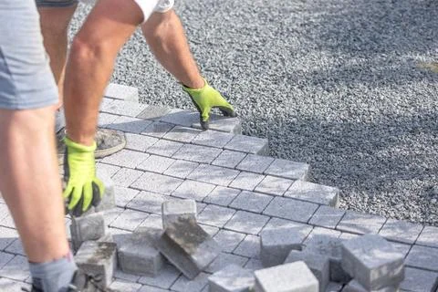 Worker building a new interlocking pavement from concrete paving, a new path Stock Photos