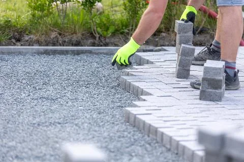 Worker building a new interlocking pavement from concrete paving, a new path Stock Photos