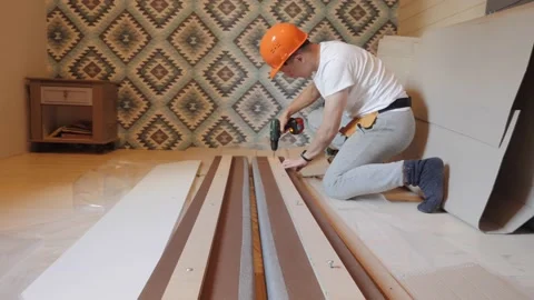 A worker builds a bed in the bedroom Видео 142158454