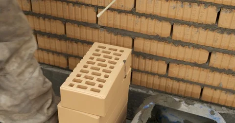 Worker Builds Brick Wall, Building House, Creating Facade Wall with Straw Brick Stock Footage 129500794