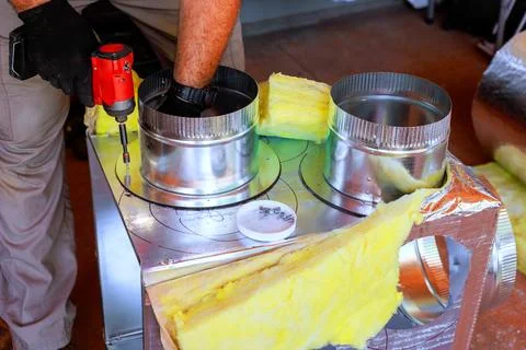 Worker builds duct system with tools using screwdriver wearing gloves Stock Photos