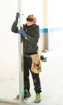 Worker builds a plasterboard wall. Stock Photos