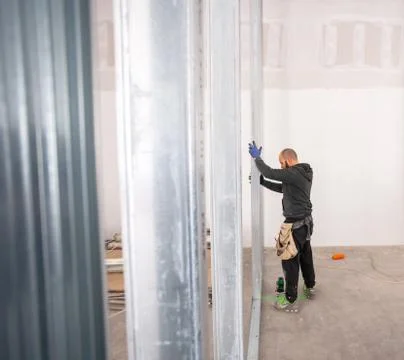 Worker builds a plasterboard wall. Stock Photos