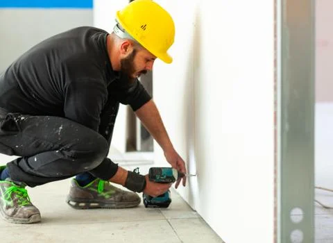 Worker builds a plasterboard wall. Stock Photos
