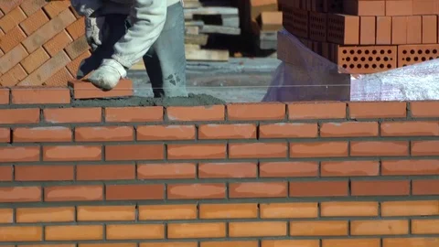 Worker builds a wall of bricks. the builder on a building makes bricklaying. the Stock Footage 84871703