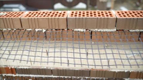 Worker builds a wall of colored brick. Worker in Close up of industrial brick Stock Photos
