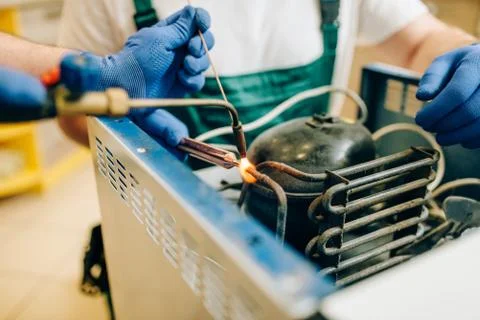 Worker with burner repairs cooling system Stock Photos
