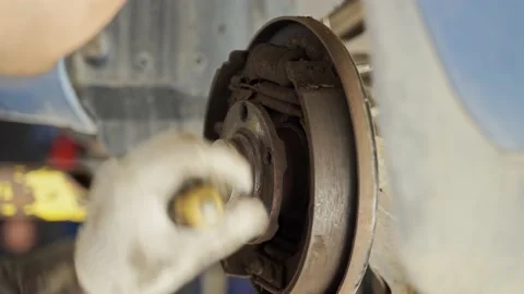 Worker cannot remove the protective cap from the vehicle hub with a screwdriver Stock Footage 171373647