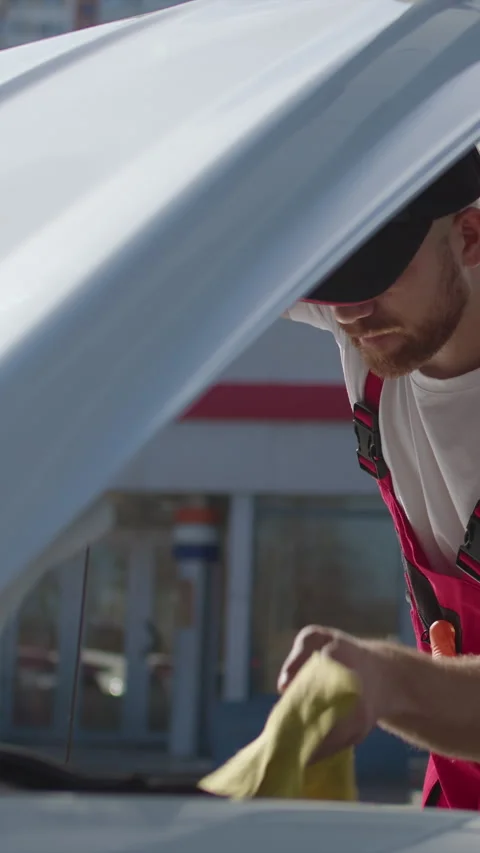 A worker from a car service, dressed in work clothes, checks the quantity and Stock Footage 276262224