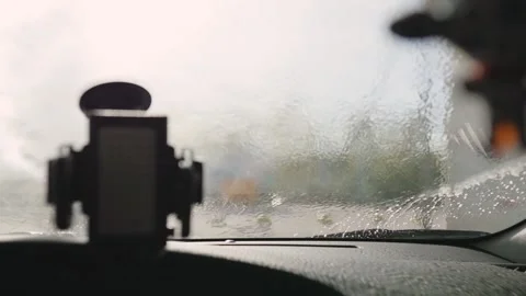 Worker in car washing shop throwing soap on car window. View from inside the car Stock-Footage 130862331