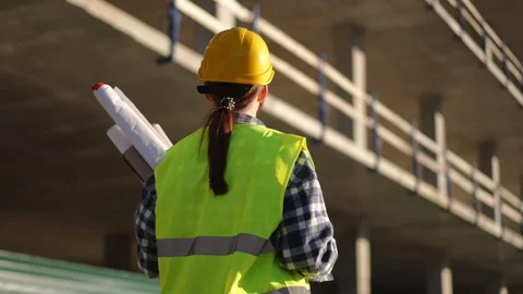 Worker Carefully Reviewing Detailed Blueprints at the Construction Site Stock Footage 311862053