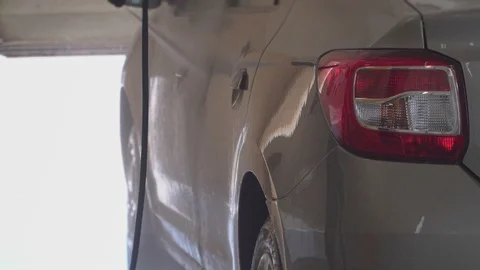The worker carefully washes the car at the car wash close up Stock Footage 105966064
