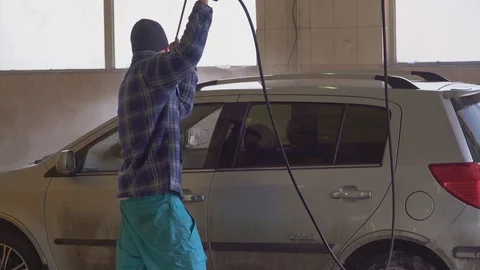The worker carefully washes gray car at the car wash Stock Footage 105966198