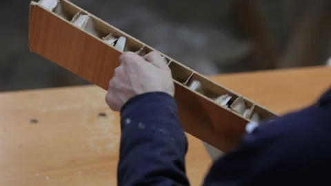 Worker in carpentry workshop breaks piece of door leaf with hands, poor door Stock Footage 132723173