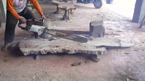 Worker of carpentry workshop in dust is sawing wooden board with chainsaw Video stock 151242396