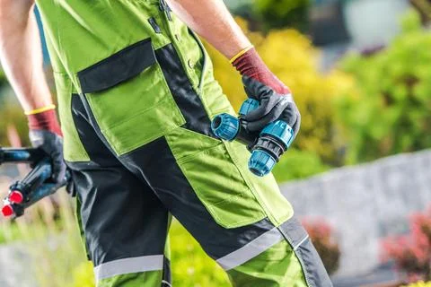 Worker Carries Irrigation Elements in Garden Area During Daytime Stock Photos