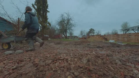 A worker carries a wheelbarrow Stock Footage 333014538