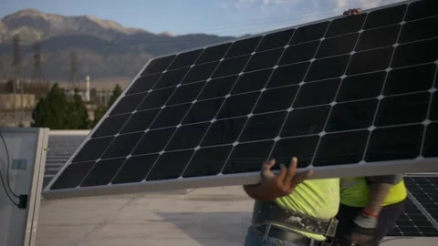 Worker carry a solar panel to install on roof for clean renewable energy Stock Footage 257384794