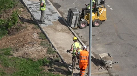 Worker carry stack of tiles with special machine and pave sideway. 4K Stock Footage 56542390