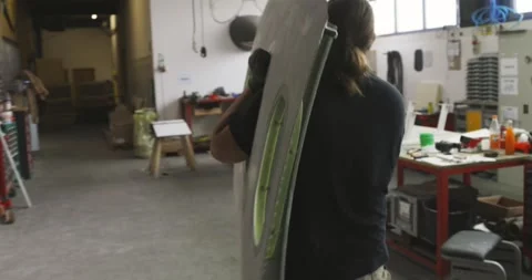 Worker Carrying Green Aircraft Panel Through Fabrication Workshop, Medium Shot Видео 340303580